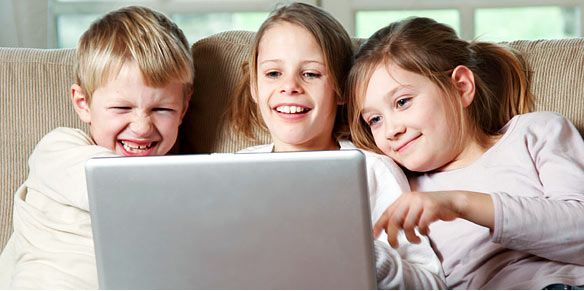 Kids laughing in front of a computer